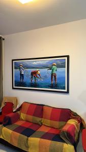 ein Gemälde an der Wand über einem Sofa in der Unterkunft Flat - Condomínio Brisa da Serra - Gravatá in Gravatá + 27 Fotos