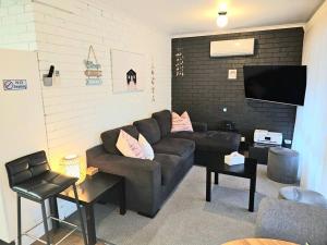 a living room with a couch and a flat screen tv at Central 2 Beddy on Beach Road! in Batemans Bay