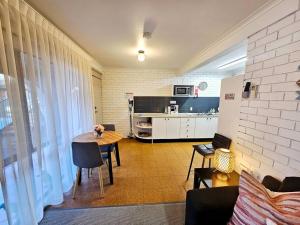 a living room with a table and a kitchen at Central 2 Beddy on Beach Road! in Batemans Bay