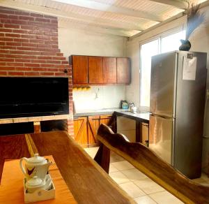 a kitchen with a wooden table and a stainless steel refrigerator at Dona Monica in Ituzaingó