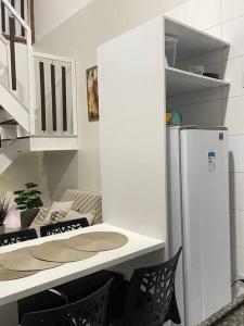 a kitchen with a refrigerator and a table and chairs at Flat Fazenda Monte Castelo in Bezerros