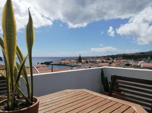 a table on a balcony with a view of the ocean at Casa Monte Queimado in Horta