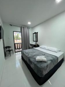 a bedroom with a bed with two towels on it at Barokah Resort in Bachok