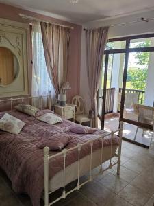 ein Schlafzimmer mit großem Bett und Balkon in der Unterkunft Beautiful and quiet family villa in Kableshkovo + 37 Fotos