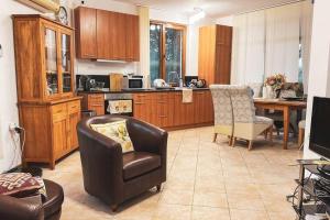 eine Küche mit einem Stuhl, einer Couch und einem Tisch in der Unterkunft Beautiful and quiet family villa in Kableshkovo