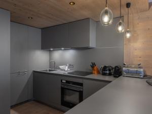una cucina con armadi grigi e piano di lavoro di Magnifique appt au cœur de Courchevel avec accès bien-être - FR-1-562-81 a Courchevel Altre 6 foto