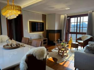 a living room with a table and a dining room at 3 dormitórios ao lado da Rua Coberta in Gramado