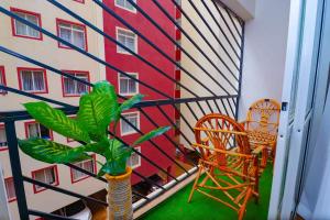 a balcony with a plant and chairs and a building at The Gem-3 Bedroom Kiambu Road-Best Rated in Nairobi
