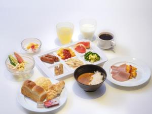 a white table with plates of food and drinks at APA Hotel Tottori Ekimae Minami in Tottori