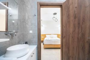a bathroom with a sink and a toilet and a bed at sunny rock 2 apartments in Lagoúdi Zía +20 photos