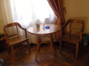 a wooden table with two chairs and a candle on it at Affittacamere Alla Stazione in Trieste