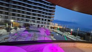 a view of a building with a pool with pink lights at Eva Del Mar 1, vedere la mare-parcare gratuita in Mamaia