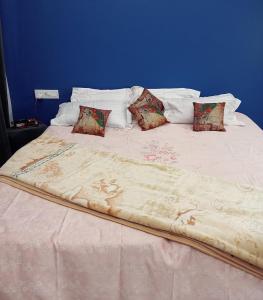a large white bed with four pillows on it at Nawabi SunRise HomeStay in Lucknow