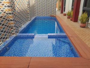 a swimming pool with blue tiles on a patio at Breeze Apartments in Nadi