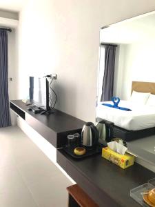 a room with a bed and a desk with a mirror at Rockstar Beach Apartments in Bang Rak Beach