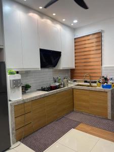 a kitchen with white cabinets and a sink at Saujana Perdana Homestay in Sungai Buluh +14 photos