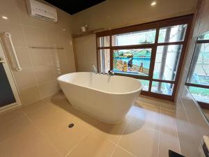 a white bath tub in a bathroom with a window at Takeya Kitano Honkan in Kyoto +28 photos