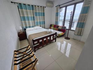 a bedroom with a bed and a couch in a room at FIJI HOME Apartment Hotel in Suva
