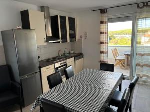 a kitchen with a table with chairs and a table and a tablecloth on at Apartment Vjera in Punat