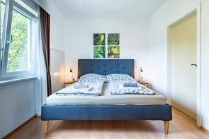 a bed with a blue headboard in a bedroom at Landhaus Danita in Bodensdorf