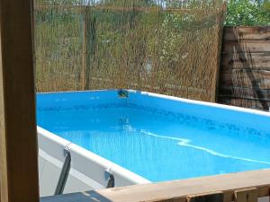 a swimming pool in a backyard with a fence at PENICHE FARNIENTE CLIMATISEE - Aux Portes de la Camargue in Bellegarde