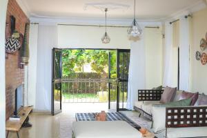 a living room with a couch and a large window at Impano Guest House in Kigali