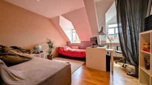 a bedroom with pink walls and a desk and a bed at Großzügige Maisonette über dem Leipziger Zentrum in Leipzig