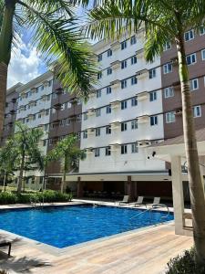 a hotel with a swimming pool in front of a building at SyHOME-Suites in Trece Martires