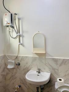 a bathroom with a sink and a shower and a toilet at Francis Dale Lodge L6 in El Nido