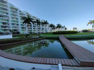 un grand immeuble avec un étang en face dans l'établissement Beachfront Bliss at Aria Ocean Flamingos, à Nuevo Vallarta