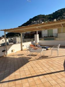 un patio con tavolo e sedie sul tetto di Le Case di Don Andrea a Minori