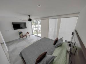 - une chambre avec un lit doté d'oreillers et une télévision dans l'établissement Beachfront Bliss at Aria Ocean Flamingos, à Nuevo Vallarta