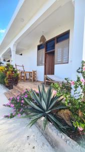 a house with flowers in front of it at Maisha ni sasa Bungalows in Nungwi