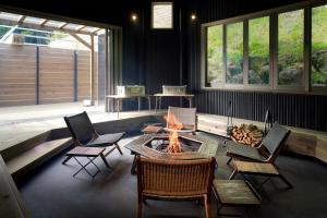 a living room with a fire pit and chairs at The BASE GLAMPING YUGAWARA in Yugawara
