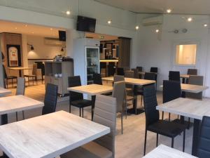Un restaurante con mesas y sillas en una sala. en Brit Hotel Salon de Provence, en Salon-de-Provence