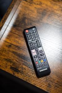a remote control sitting on top of a wooden table at Villa Falco Bianco in Buşteni