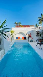 a blue swimming pool with a bed in a house at Villa Padi Pakem in Pakem