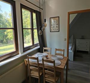ein Esszimmer mit Tisch, Stühlen und Fenstern in der Unterkunft Beekenhof in Bommelsen