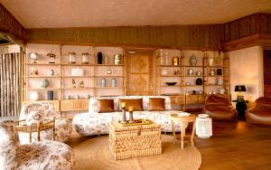 a living room with a couch and chairs and shelves at One Nature Mara River in Serengeti National Park