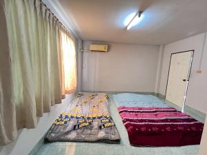 ハジャイにあるPhugingkarn Home Hat Yaiの窓のある部屋のベッド