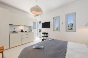 Un dormitorio blanco con una cama y una cocina. en Sea Pearls Villas, en Ampelas