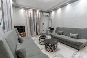 a living room with two couches and a tv at BSP RENT ROOMs in Paralia Sikias