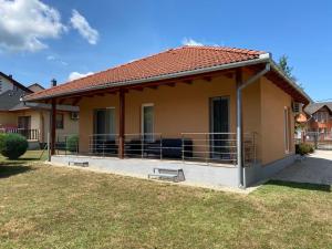 a small house with a porch and a grass yard at Pimkie Apartman in Zalakaros