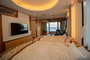 una camera d'albergo con due letti e una TV a schermo piatto di La-se-ri Resort & Stay - Vacation STAY 63368v a Himi