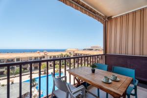 Un balcón con mesa y sillas y una piscina. en Balcón del mar - suite 353, en Costa del Silencio