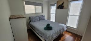 a small bedroom with a bed with a green duck on it at Recovery On Discovery Holiday House in Agnes Water