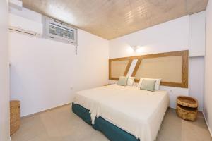 Un dormitorio con una cama en una habitación blanca. en Sea Pearls Villas, en Ampelas 161 fotos más