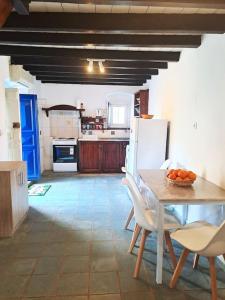 a kitchen with a table and chairs and a refrigerator at Ο Παράδεισος της Αφροδίτης in Kalymnos