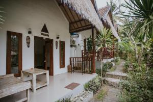 una casa con un porche con un banco en el lateral en Alam Selumbung Garden, en Nusa Penida