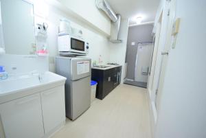 a kitchen with white cabinets and a microwave at Sumuka Asato Station 1K[F-5] in Naha
